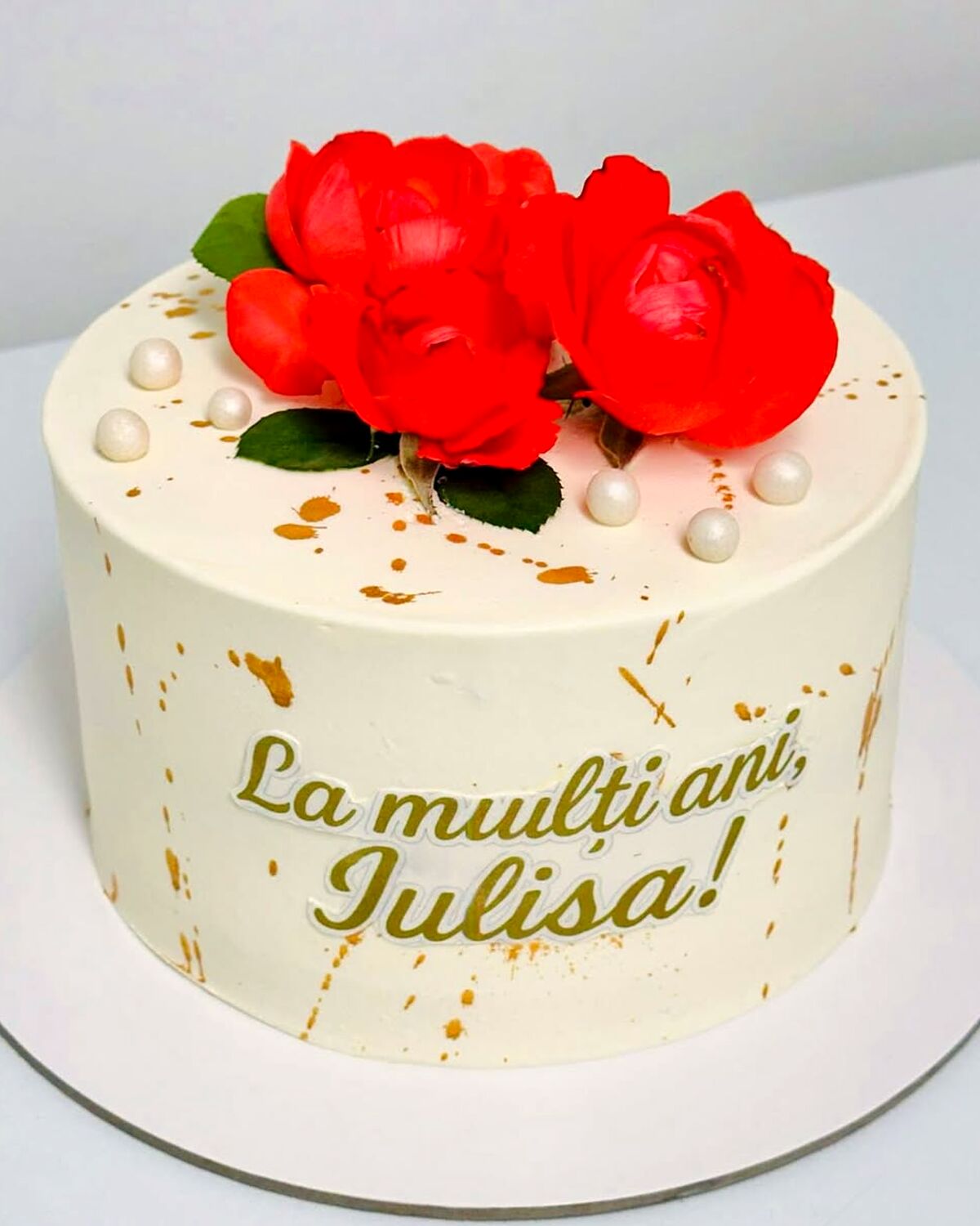 Tort crem cu trandafiri roșii naturali și stropi aurii, făcut la Nadine Atelier